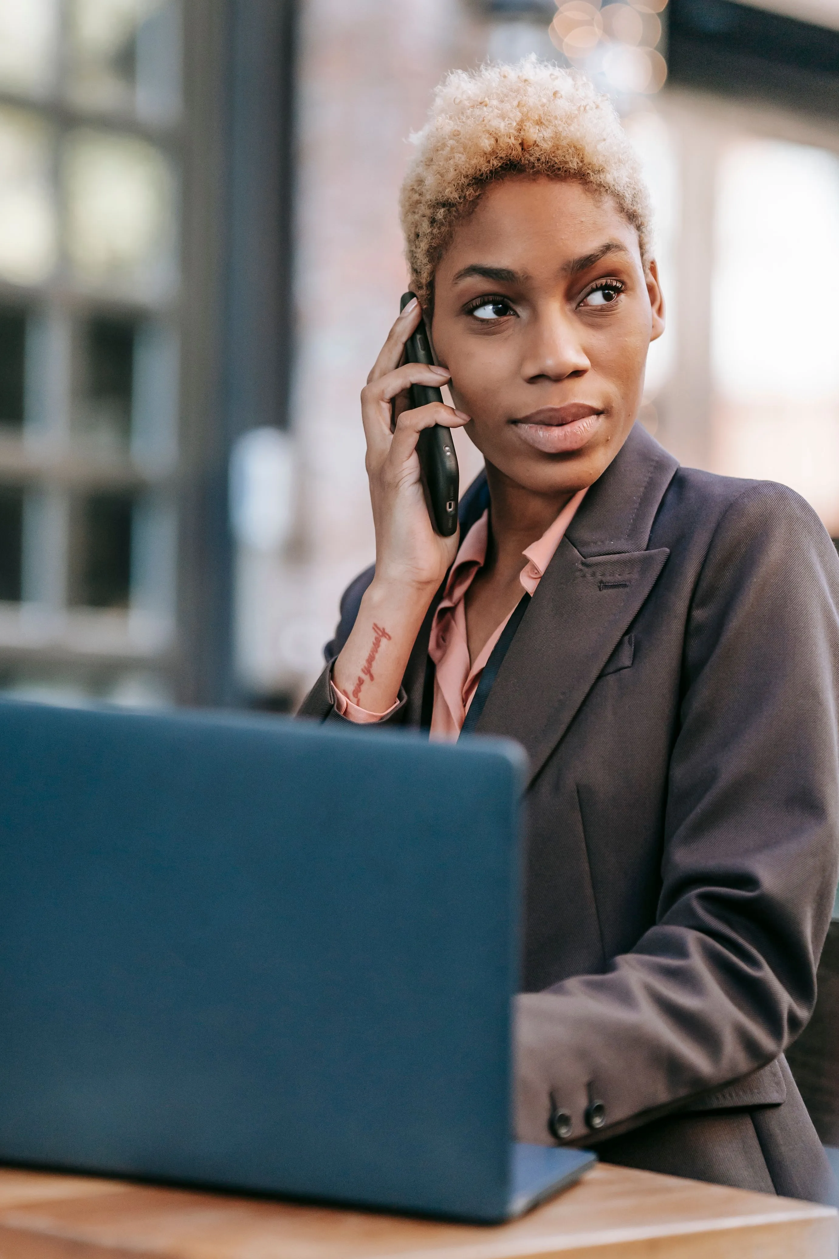 A woman smiling on a phone call at her desk