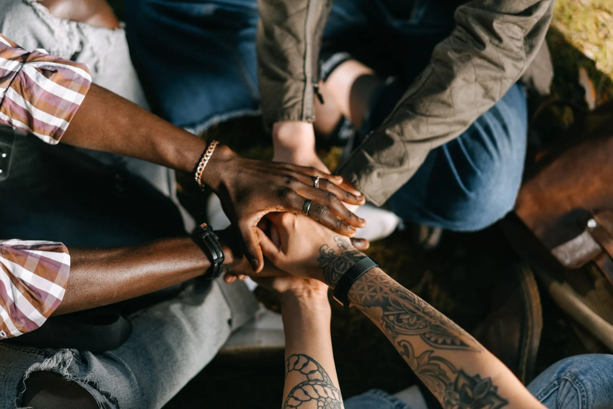 Hands stacked together in the middle of a circle of people