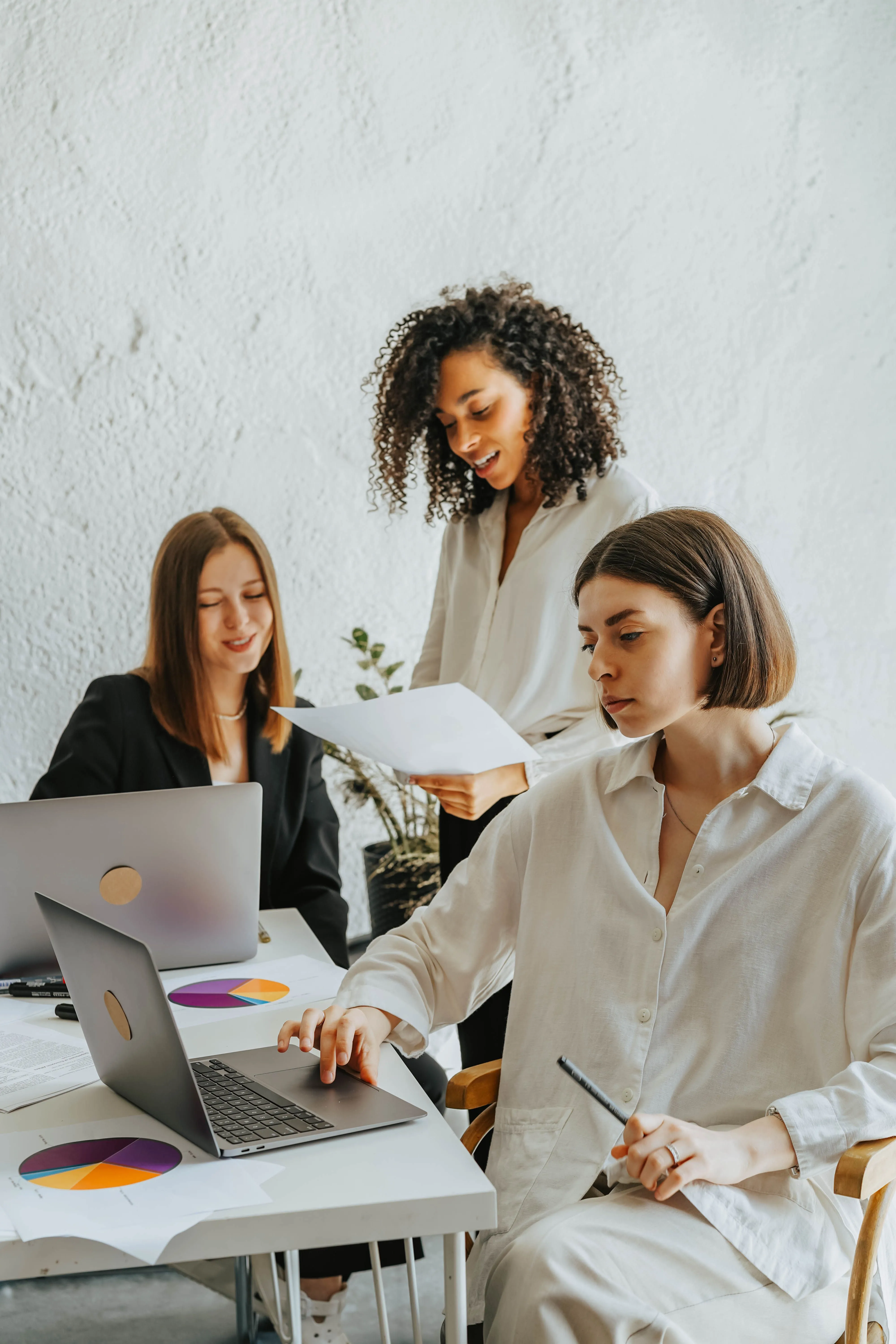 Three nonprofit staff members reviewing program documents together at a shared desk