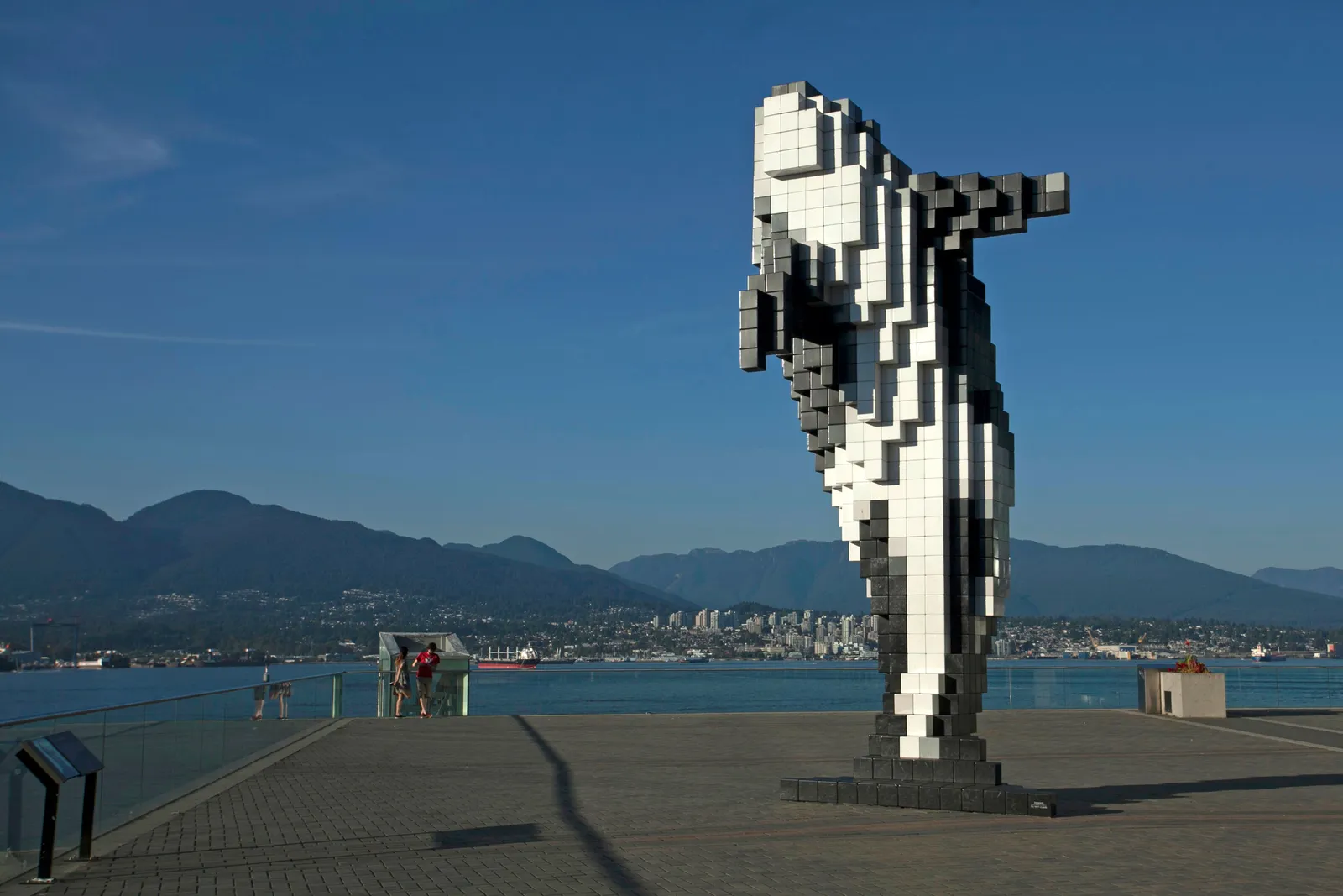 The Digital Orca sculpture on the Vancouver waterfront, the North Shore mountains and the harbour behind it