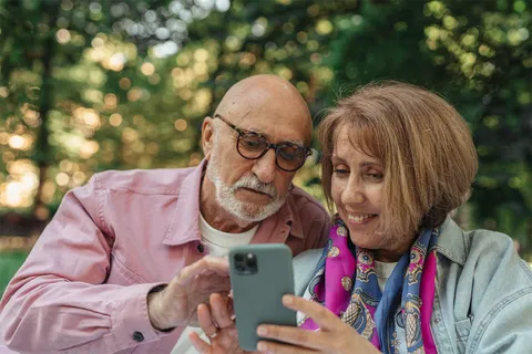 An older couple smiling at a phone together