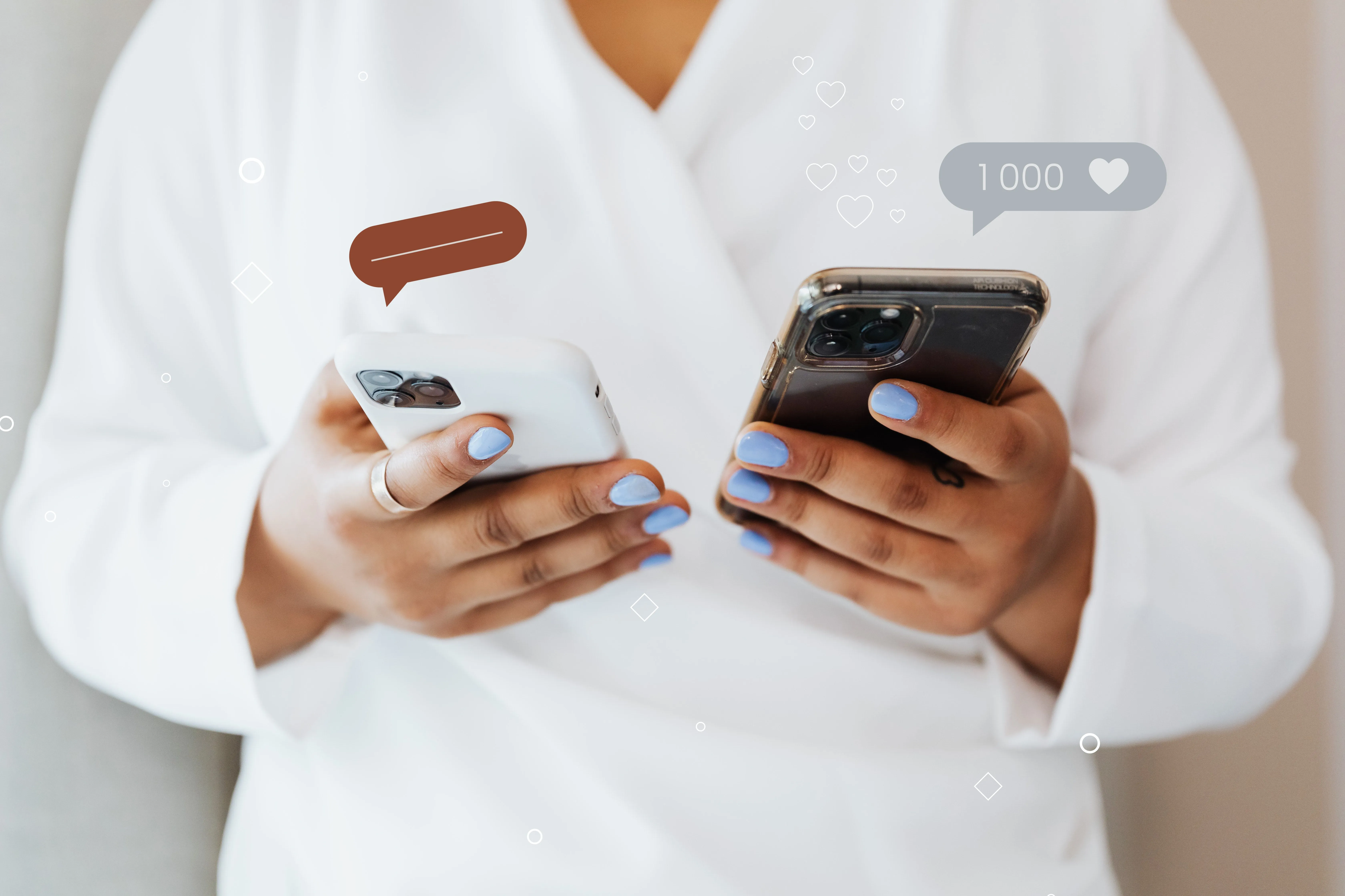 Hands holding two phones with social media reactions floating around them