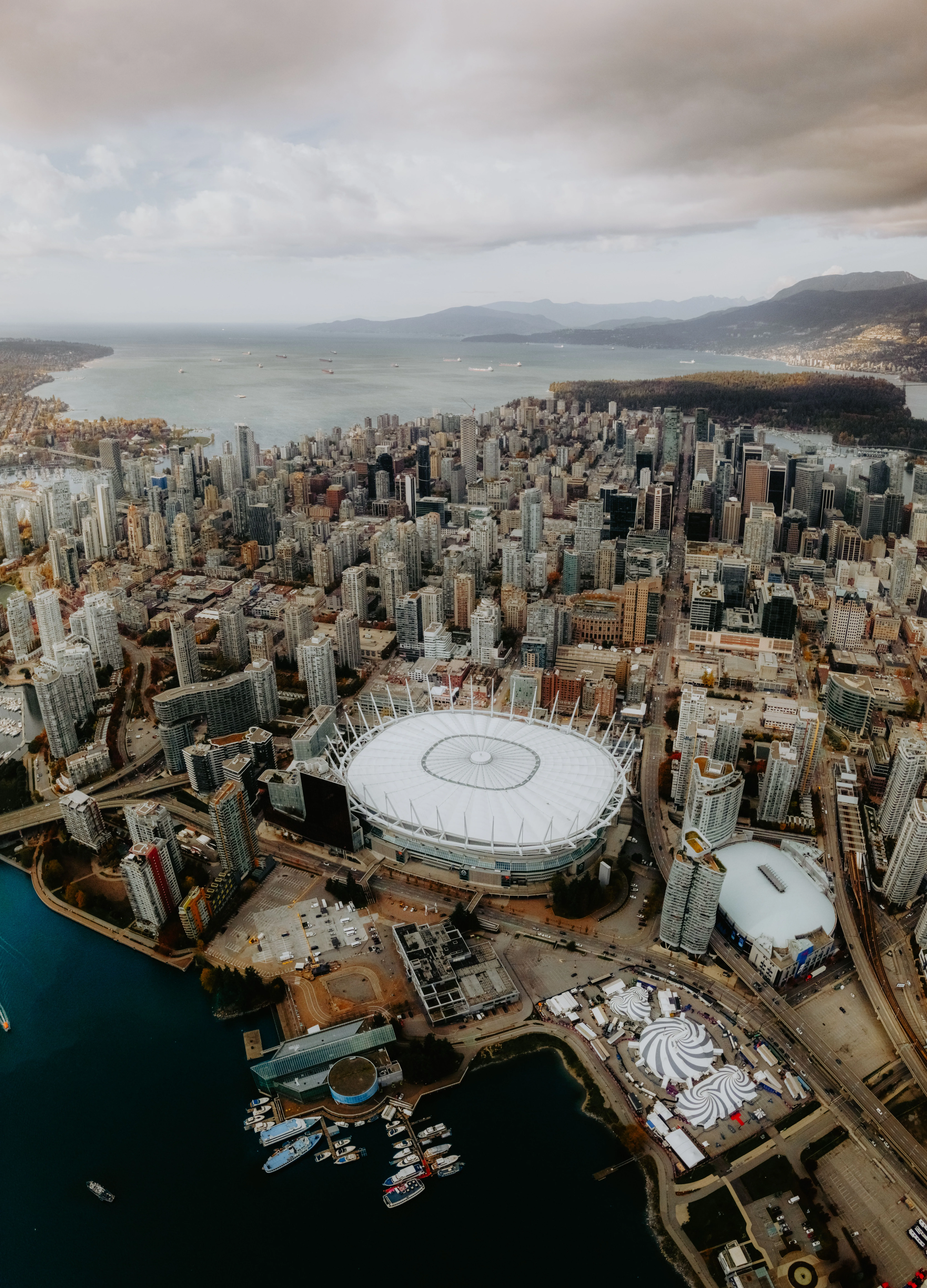Aerial view of downtown Vancouver, the harbour, and the mountains beyond